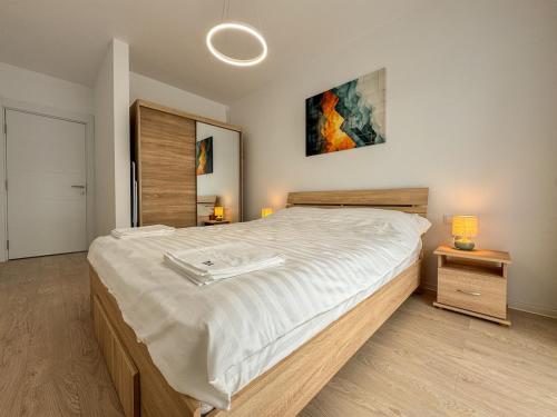 a bedroom with a large bed with white sheets at Dorian's Apartments-Blvd Muncii 1 in Cluj-Napoca
