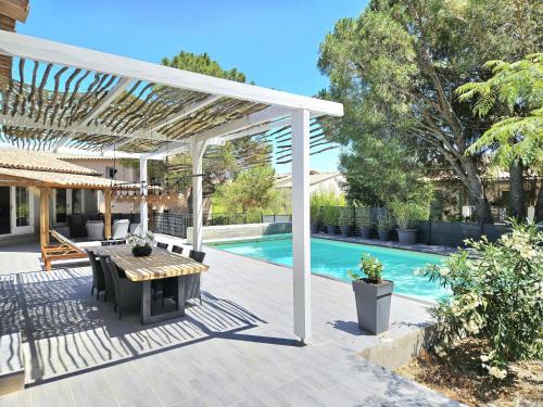 une pergola blanche au-dessus d'une terrasse avec piscine dans l'établissement Lunes, au Plan-de-la-Tour