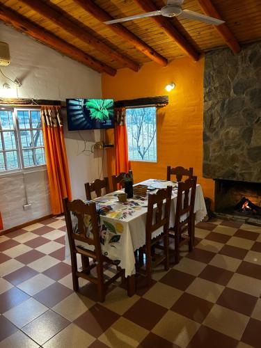 a dining room with a table and a fireplace at cabañas Villa de las rosas in Villa de Las Rosas
