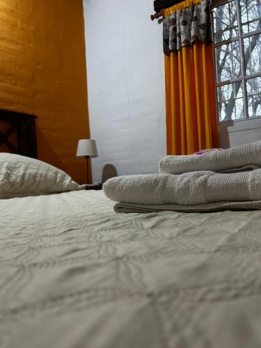 a pile of towels sitting on top of a bed at cabañas Villa de las rosas in Villa de Las Rosas