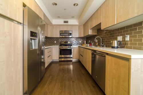 cocina grande con suelo de madera y electrodomésticos de acero inoxidable en Western Romaine, en Los Ángeles