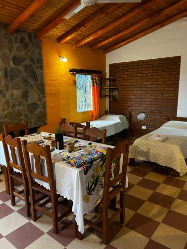 a room with a table and chairs and a bedroom at cabañas Villa de las rosas in Villa de Las Rosas