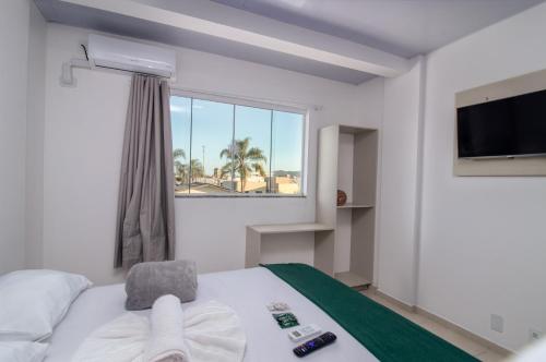 a hotel room with a bed and a window at Pousada Paraná in Penha