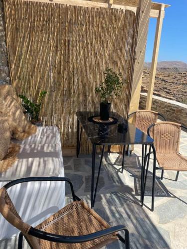 a table and chairs on a patio with a view at Darsi suites Kythnos in Kithnos