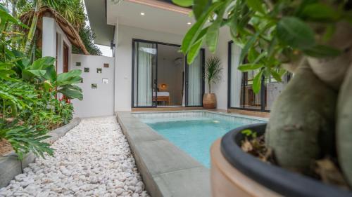 a swimming pool in the middle of a house with plants at Baan View Talay Pool Villas in Thong Nai Pan Yai