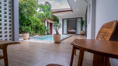 a living room with a table and a swimming pool at Baan View Talay Pool Villas in Thong Nai Pan Yai