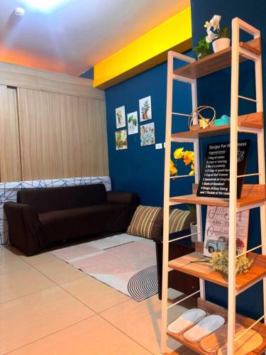 a living room with a couch and a shelf at SLY Staycation at Shore Residences Mall of Asia in Manila