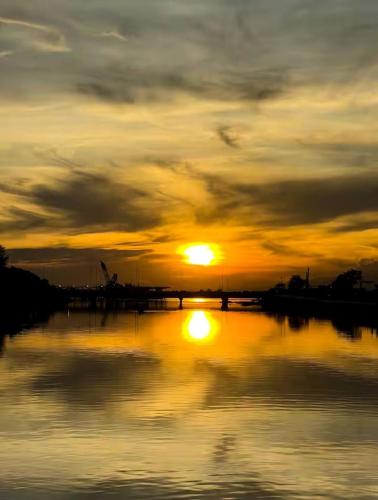 a sunset over a body of water with the sun at SLY Staycation at Shore Residences Mall of Asia in Manila