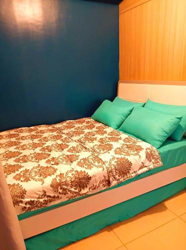a bedroom with a bed with a blue wall at SLY Staycation at Shore Residences Mall of Asia in Manila