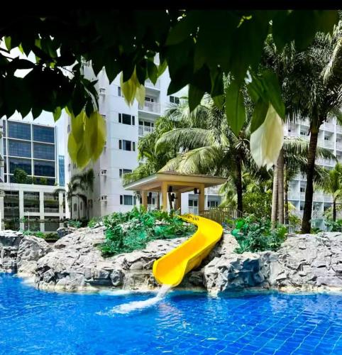 a yellow slide in the middle of a pool at SLY Staycation at Shore Residences Mall of Asia in Manila