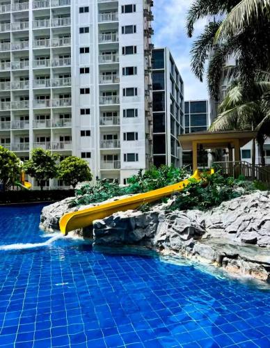 a pool at a resort with a slide at SLY Staycation at Shore Residences Mall of Asia in Manila