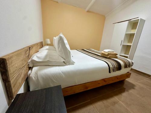 a bedroom with a bed with white sheets and a table at turisolcor atacama in San Pedro de Atacama