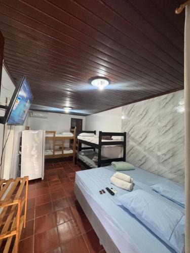 a room with a bed and a tv in a room at Pousada Pé Na Areia - ilha do mel in Paranaguá