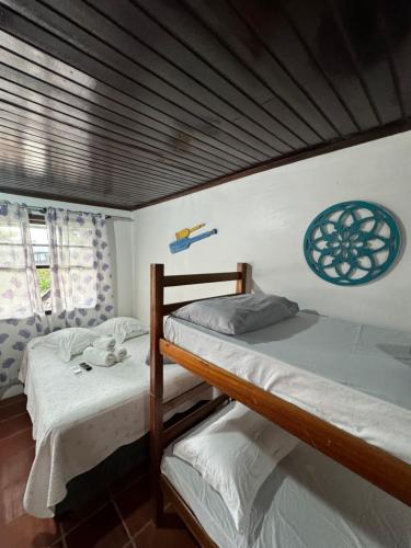 two bunk beds in a room with a wooden ceiling at Pousada Pé Na Areia - ilha do mel in Paranaguá
