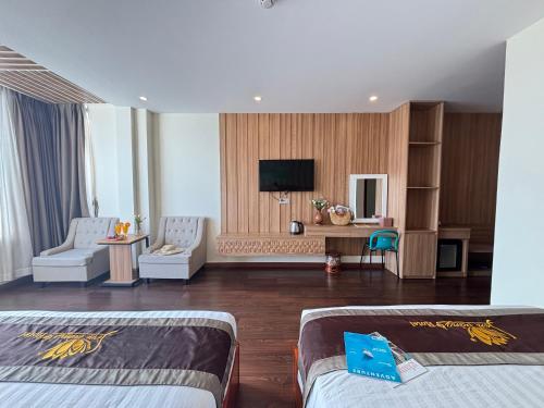 a hotel room with two beds and a flat screen tv at Sen Vàng Luxury Hotel in Nha Trang