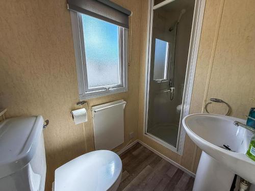 a bathroom with a toilet and a sink and a shower at Great Caravan At Valley Farm Holiday Park, Essex Ref 46583V in Great Clacton