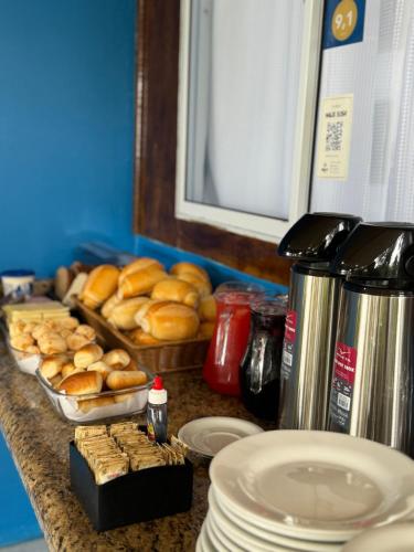 a counter top with bread and a tray of pastries at Pousada Pé Na Areia - ilha do mel in Paranaguá