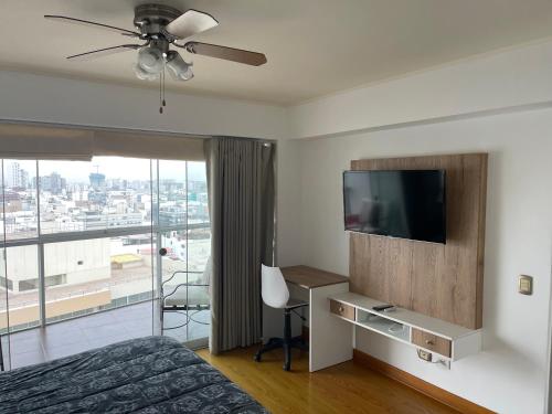 a bedroom with a bed and a flat screen tv at Book in Miraflores - Lima in Lima