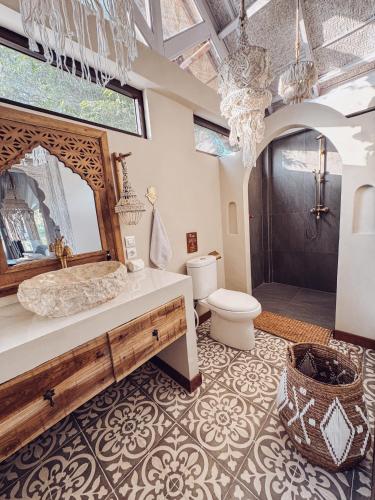 a bathroom with a sink and a toilet and a mirror at Casa Magick boutique Villa in Gili Islands