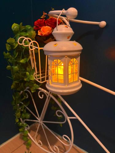 a lighted lantern on a stand next to a plant at SLY Staycation at Shore Residences Mall of Asia in Manila