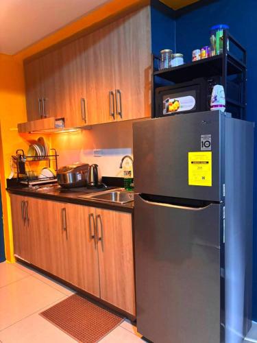 a kitchen with a stainless steel refrigerator and a sink at SLY Staycation at Shore Residences Mall of Asia in Manila