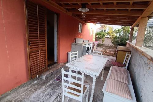 a table and chairs on the porch of a house at Seaside holiday house Jezera, Murter - 23324 in Jezera