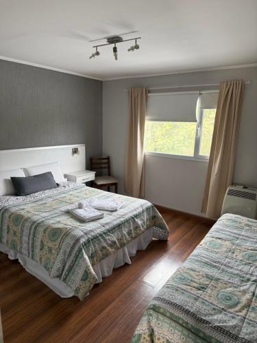 a bedroom with two beds and a window at Ak´Para in Tandil
