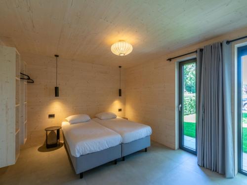 a bedroom with a bed and a large window at Luxury holiday home by the sea in Sint Maartenszee