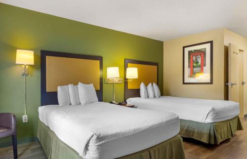 two beds in a hotel room with green walls at Extended Stay America Suites - Houston - NASA - Johnson Space Center in Nassau Bay