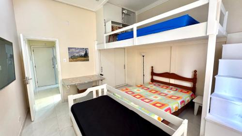 a bedroom with a bunk bed and a bunk bed at Studio 102 Pitangueiras no térreo - ar condicionado - na quadra da praia! in Guarujá