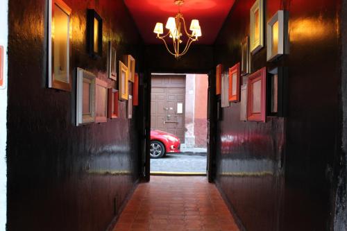 a hallway with a red car parked in a garage at Hotel Punto 79 in San Miguel de Allende