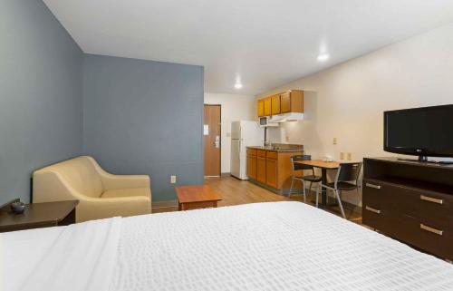 a bedroom with a bed and a kitchen with a tv at Extended Stay America Select Suites - Phoenix - North in John C Lincoln Helistop