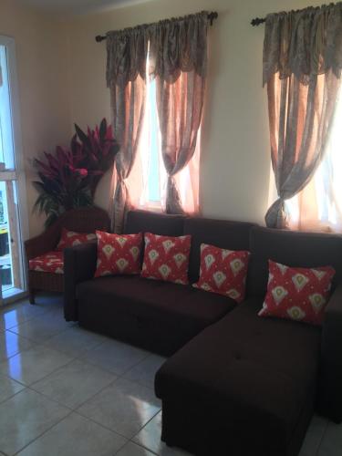 a living room with a couch and two windows at Scotland Villa-Dominica in Canefield