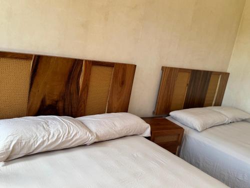 a room with two beds with white sheets at Otoch Maya in Valladolid