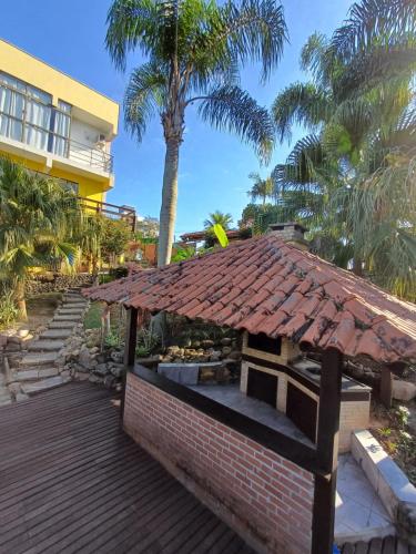 a brick building with a tile roof on a deck at Suíte Pachamama in Bombinhas