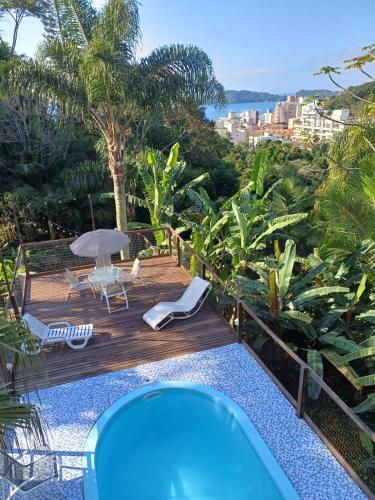 a hot tub on a wooden deck with a view of the ocean at Suíte Pachamama in Bombinhas
