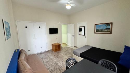une chambre avec un lit et un salon dans l'établissement Studio 308 nas Pitangueiras - na quadra da praia!, à Guarujá