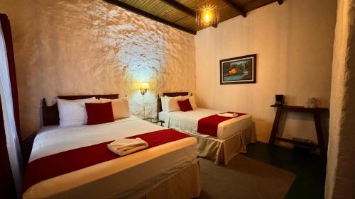 een slaapkamer met twee bedden in een kamer bij Garden Hotel in Copan Ruinas
