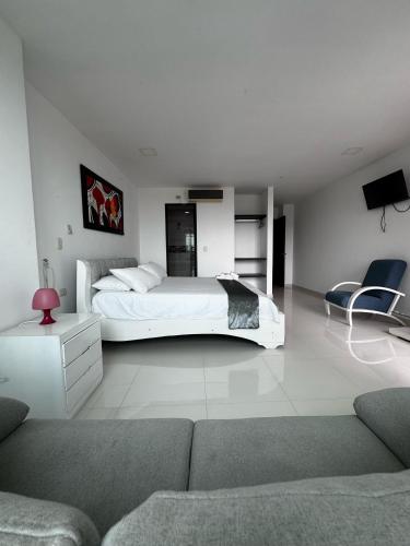 a white bedroom with a bed and a couch at Scherezade Hotel&Resorts in Aguachica