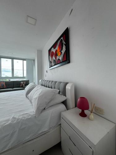 a bedroom with a bed and a red lamp on a night stand at Scherezade Hotel&Resorts in Aguachica