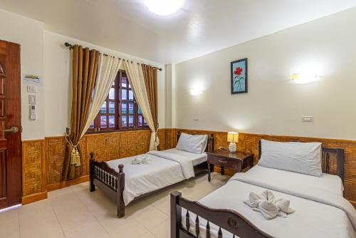 a bedroom with two beds and a window at coucou br hotel in Pooc