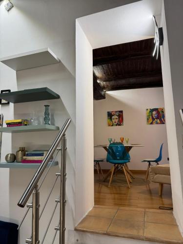 a kitchen and dining room with white walls and wooden floors at Aria B&B - apartment in the historic center in Spoleto