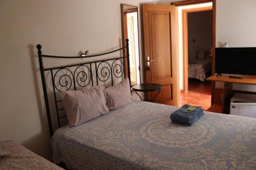 a bedroom with a bed with a suitcase on it at Quartos Vasco da Gama in Porto Covo