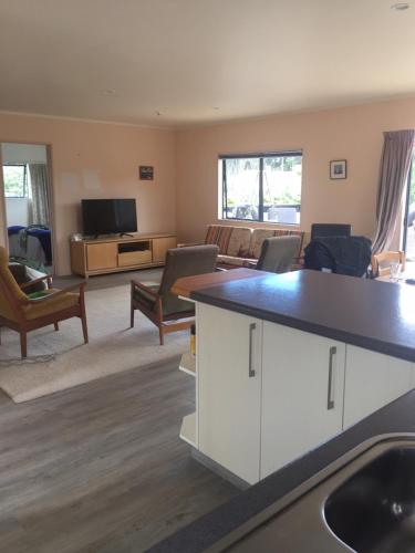 a large living room with a kitchen and a living room at Warm Cosy holiday home right in town in Raglan