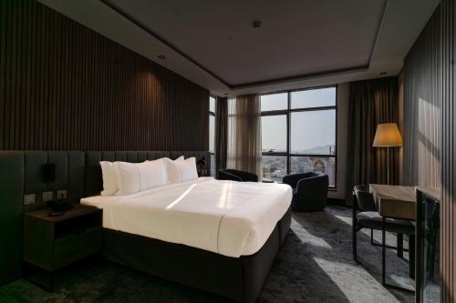 a hotel room with a large bed and a window at فندق هيل Hill Hotel in Al Madinah