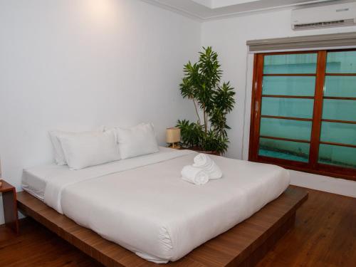 a bedroom with a large white bed with a window at Boracay Beach Club in Boracay