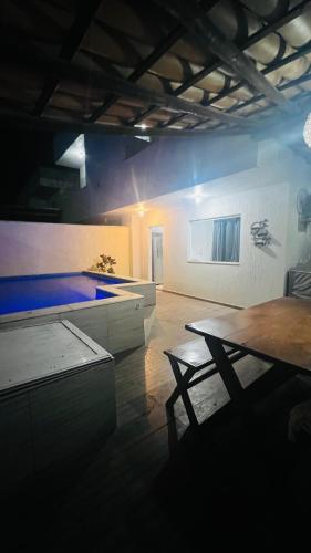 a large room with a swimming pool and a table at Bahia Bella Casa 01 in Santa Cruz Cabrália