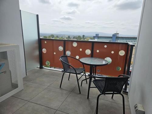 a balcony with a table and chairs and a window at Glen Oasis - Luxury Apartment in Glen Waverley
