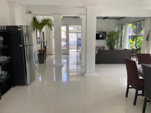 ein großer Raum mit weißem Fliesenboden und ein Esszimmer in der Unterkunft Casa Donde Entra la Luz y Vive la Naturaleza CCTV in Cozumel