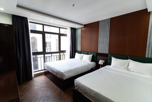 a hotel room with two beds and a window at Mama Hotel And Apartment - Free Sauna And Gym in Da Nang